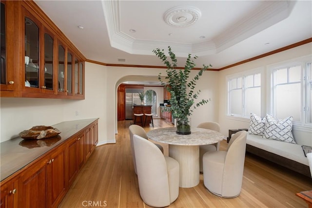 24352 Santa Clara Ave, Dana Point, CA 92629 - dining space featuring arched walkways, light wood-style floors, plenty of natural light, a raised ceiling, and ornamental molding