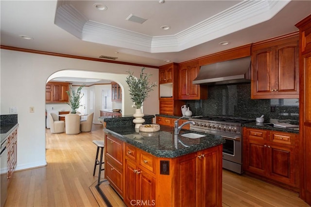 24352 Santa Clara Ave, Dana Point, CA 92629 - kitchen with stainless steel appliances, wall chimney exhaust hood, arched walkways, ornamental molding, and light wood finished floors