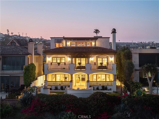 24352 Santa Clara Ave, Dana Point, CA 92629 - back of house at dusk featuring a balcony, stucco siding, and an outdoor hangout area