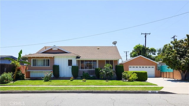 view of front facade featuring a detached garage and roof with shingles