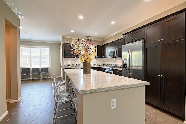 2303 Jefferson St Unit 1215, Torrance, CA 90501 - kitchen with stainless steel appliances, ornamental molding, light tile patterned flooring, a center island, and light stone counters