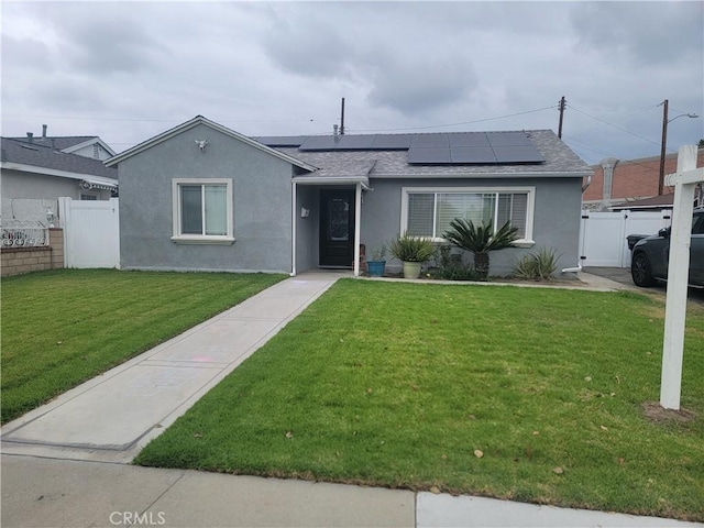 ranch-style home with solar panels, roof with shingles, stucco siding, and a gate