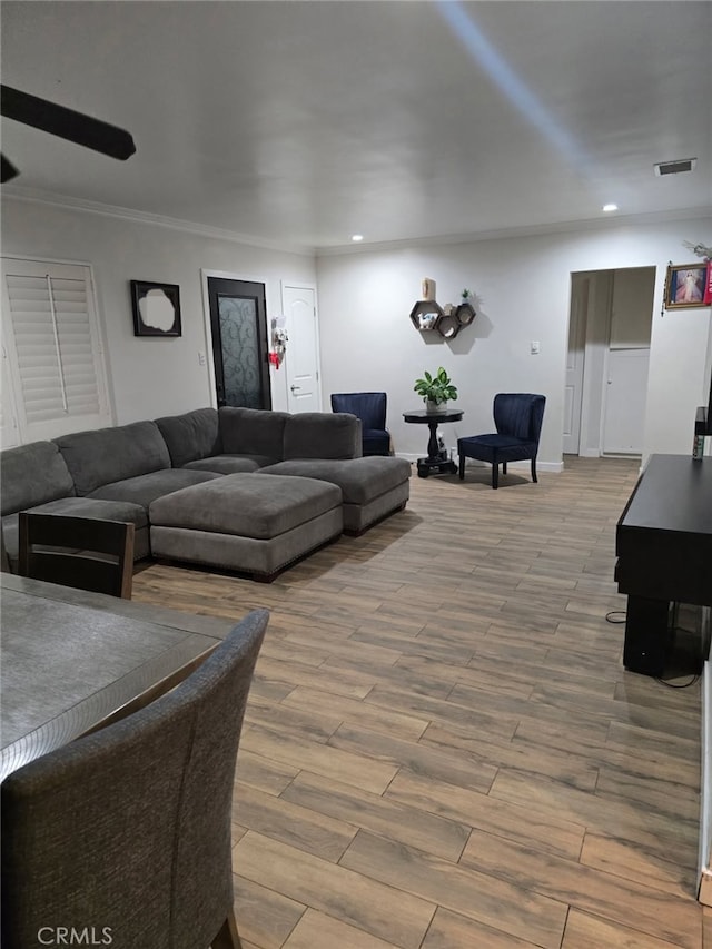 living room featuring recessed lighting, wood finished floors, crown molding, and baseboards
