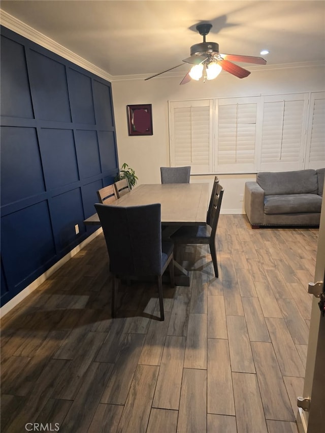dining space featuring ceiling fan, dark wood-type flooring, and crown molding
