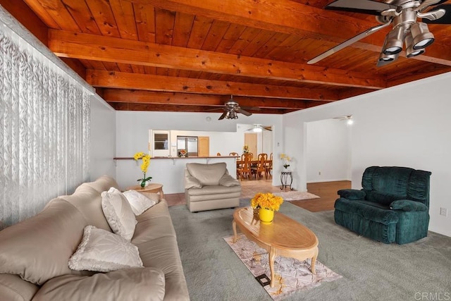 living area featuring a ceiling fan, wood ceiling, beam ceiling, and carpet floors