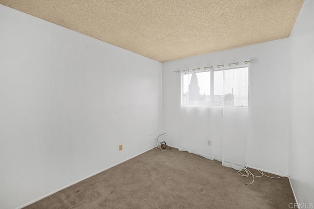 carpeted empty room with a textured ceiling