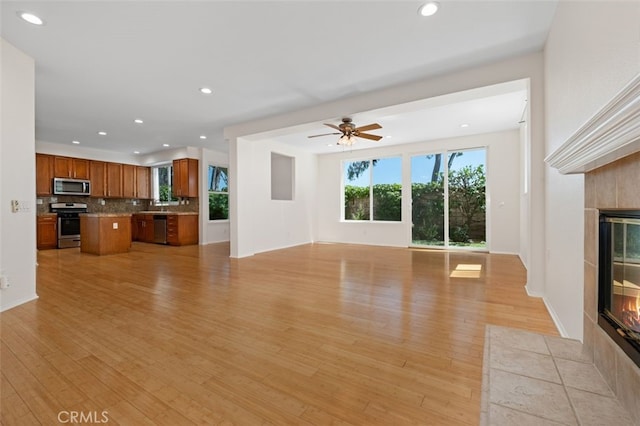 8542 E Heatherview Ln, Orange, CA 92869 - unfurnished living room with a fireplace, a ceiling fan, light wood finished floors, and recessed lighting