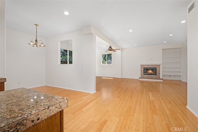8542 E Heatherview Ln, Orange, CA 92869 - unfurnished living room featuring light wood finished floors, a glass covered fireplace, ceiling fan, recessed lighting, and a chandelier