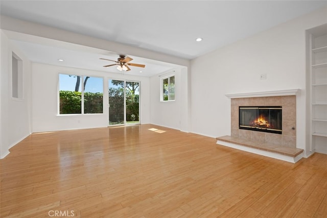 8542 E Heatherview Ln, Orange, CA 92869 - unfurnished living room featuring light wood-style floors, a fireplace, ceiling fan, recessed lighting, and built in features