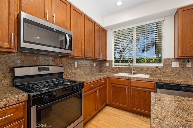 8542 E Heatherview Ln, Orange, CA 92869 - kitchen with appliances with stainless steel finishes, a sink, light wood-style flooring, brown cabinets, and recessed lighting