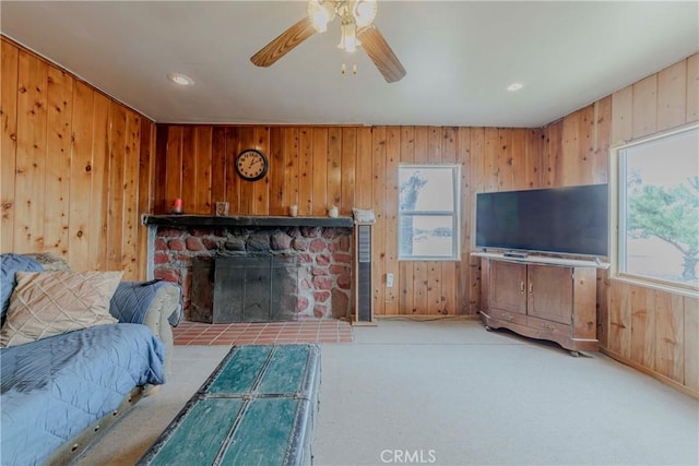 8288 White Rd, Phelan, CA 92371 - living area featuring carpet, plenty of natural light, a fireplace, wood walls, and a ceiling fan