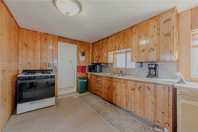 8288 White Rd, Phelan, CA 92371 - kitchen featuring gas stove, a sink, light countertops, backsplash, and wooden walls