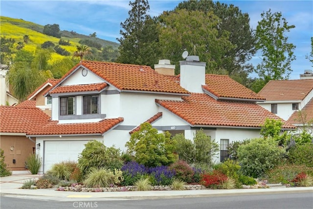 4017 Cottonwood Grove Trl, Calabasas, CA 91301 - view of front of property featuring stucco siding, a tiled roof, a chimney, and a garage