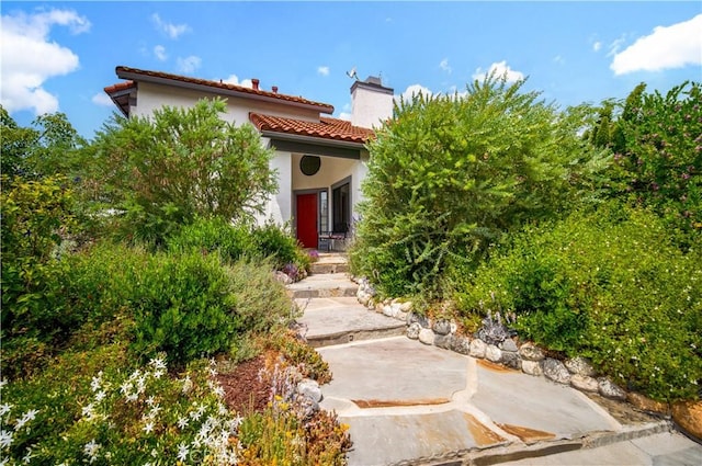 4017 Cottonwood Grove Trl, Calabasas, CA 91301 - view of exterior entry featuring a chimney, a patio area, stucco siding, and a tiled roof