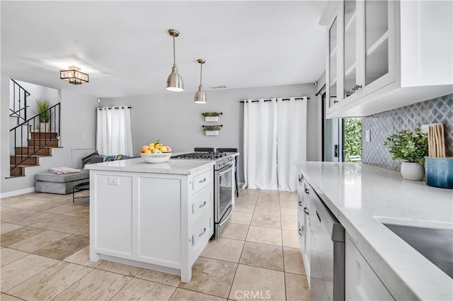 4017 Cottonwood Grove Trl, Calabasas, CA 91301 - kitchen with appliances with stainless steel finishes, white cabinetry, glass insert cabinets, pendant lighting, and light stone counters