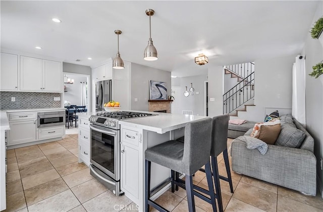 4017 Cottonwood Grove Trl, Calabasas, CA 91301 - kitchen featuring stainless steel appliances, light countertops, white cabinetry, open floor plan, and recessed lighting