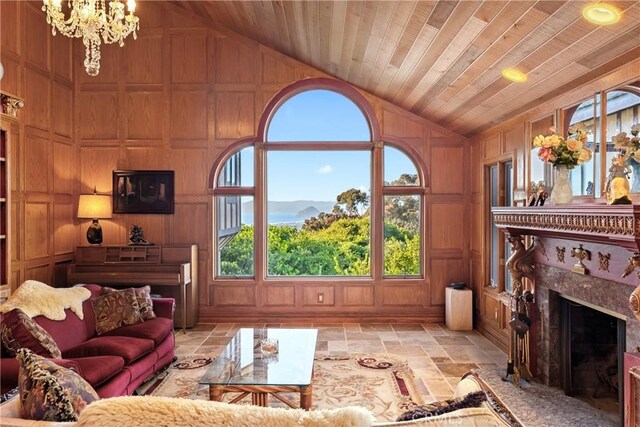 2743 Rodman Dr, Los Osos, CA 93402 - living room featuring vaulted ceiling, stone tile floors, healthy amount of natural light, a fireplace, and a chandelier