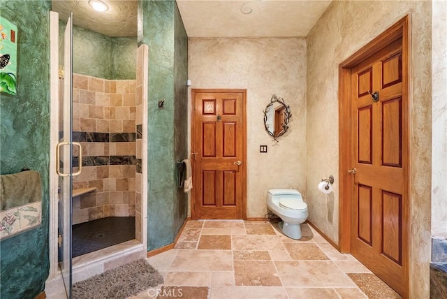 2743 Rodman Dr, Los Osos, CA 93402 - bathroom with a shower stall, baseboards, stone tile floors, and toilet