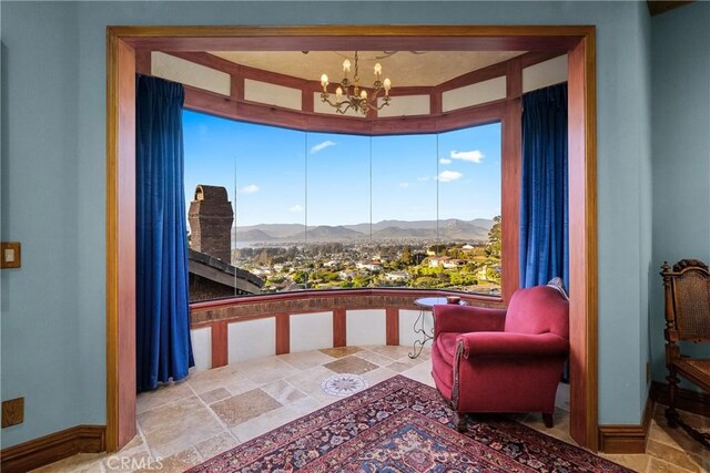 2743 Rodman Dr, Los Osos, CA 93402 - sitting room featuring a mountain view, a chandelier, stone finish flooring, baseboards, and healthy amount of natural light