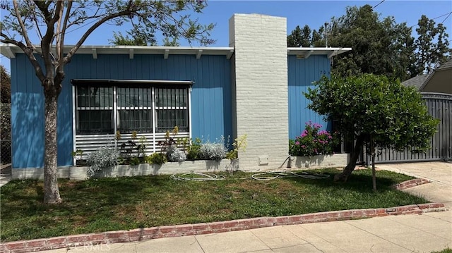 view of property exterior with a chimney and a yard