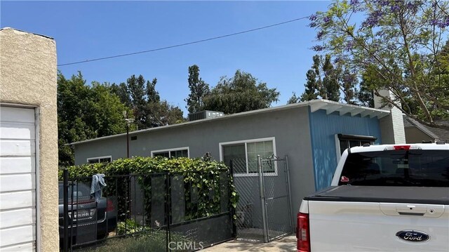 view of property exterior with fence and stucco siding