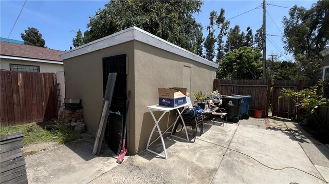view of patio featuring fence and an outdoor structure