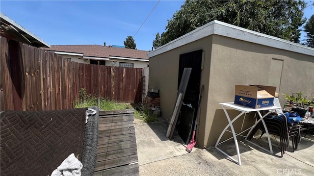view of patio / terrace with fence and an outbuilding
