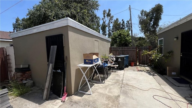 view of patio with fence and an outdoor structure