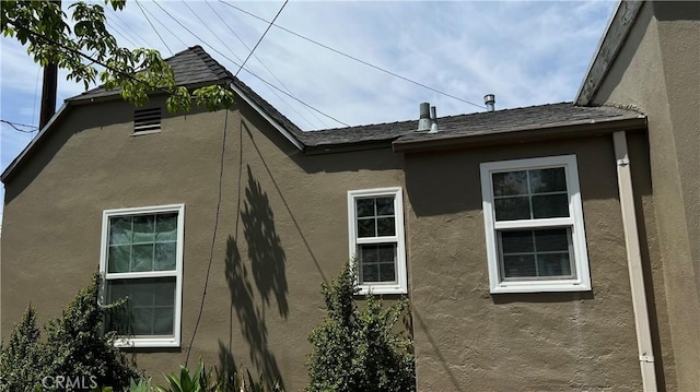 view of property exterior featuring stucco siding and a shingled roof