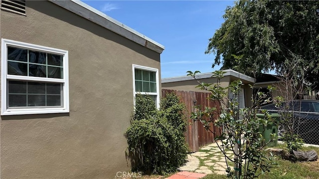 view of property exterior featuring fence and stucco siding