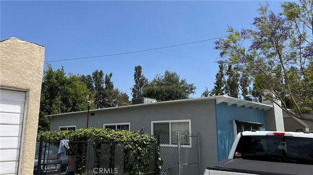 view of property exterior featuring fence and stucco siding