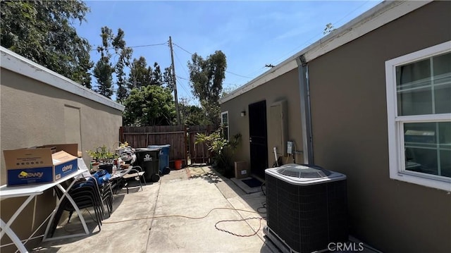 view of patio with cooling unit and fence