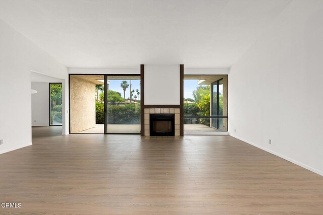 72460 Rodeo Way, Rancho Mirage, CA 92270 - unfurnished living room featuring wood finished floors, a fireplace, healthy amount of natural light, and baseboards