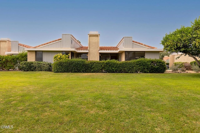 72460 Rodeo Way, Rancho Mirage, CA 92270 - back of property with a tile roof, a lawn, and a chimney