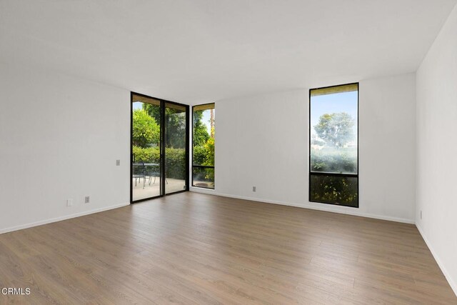 72460 Rodeo Way, Rancho Mirage, CA 92270 - spare room with expansive windows, wood finished floors, and baseboards