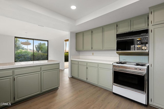 72460 Rodeo Way, Rancho Mirage, CA 92270 - kitchen featuring range, black microwave, tile countertops, light wood finished floors, and recessed lighting
