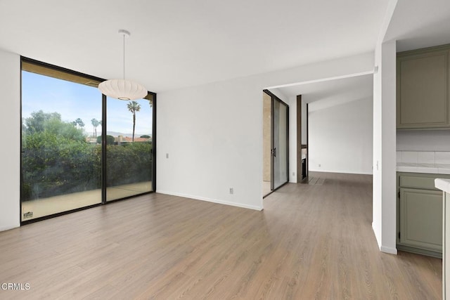 72460 Rodeo Way, Rancho Mirage, CA 92270 - unfurnished dining area with expansive windows, light wood finished floors, and baseboards