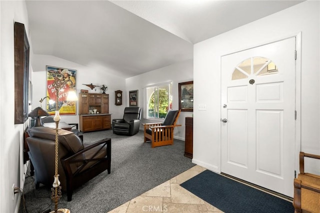 carpeted foyer entrance with lofted ceiling, stone tile floors, and baseboards