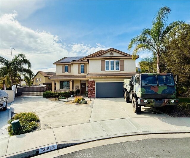 36613 Wandering Pl, Murrieta, CA 92563 - view of front of house with concrete driveway, stucco siding, a gate, roof mounted solar panels, and fence