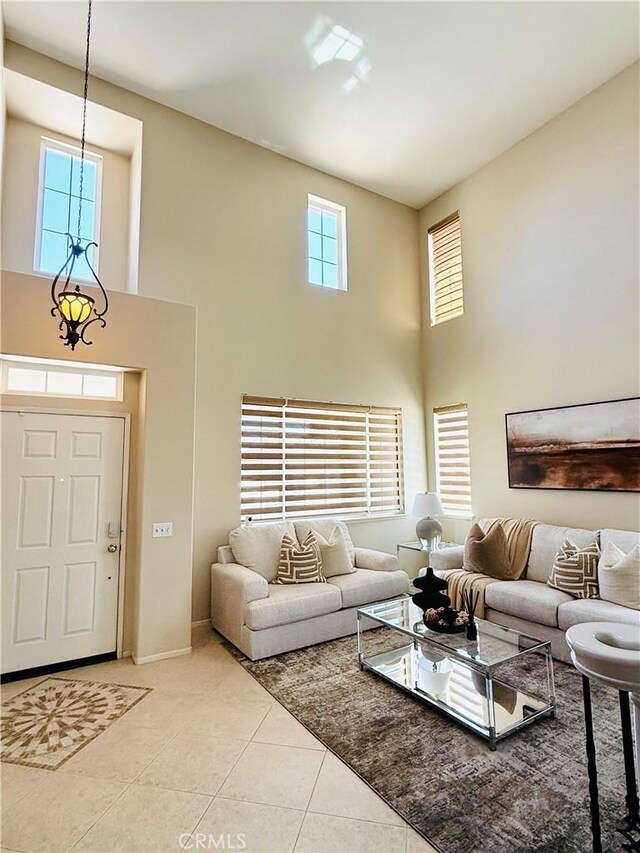 36613 Wandering Pl, Murrieta, CA 92563 - living room featuring a high ceiling, light tile patterned flooring, and baseboards