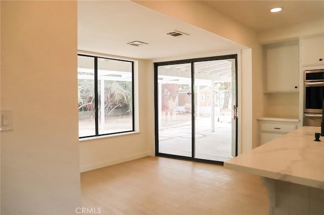 16109 Chuka Ave, Palmdale, CA 93591 - kitchen featuring white cabinetry, light wood-style floors, baseboards, stainless steel double oven, and recessed lighting