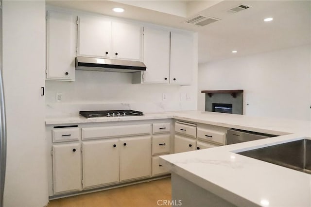 16109 Chuka Ave, Palmdale, CA 93591 - kitchen with under cabinet range hood, stovetop, recessed lighting, light countertops, and white cabinetry