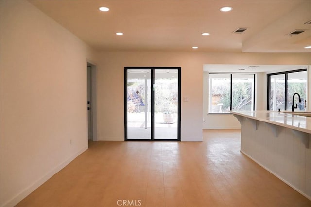 16109 Chuka Ave, Palmdale, CA 93591 - unfurnished living room with recessed lighting, healthy amount of natural light, a sink, light wood-style floors, and baseboards