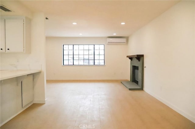16109 Chuka Ave, Palmdale, CA 93591 - unfurnished living room with an AC wall unit, a fireplace with raised hearth, light wood-style floors, recessed lighting, and baseboards