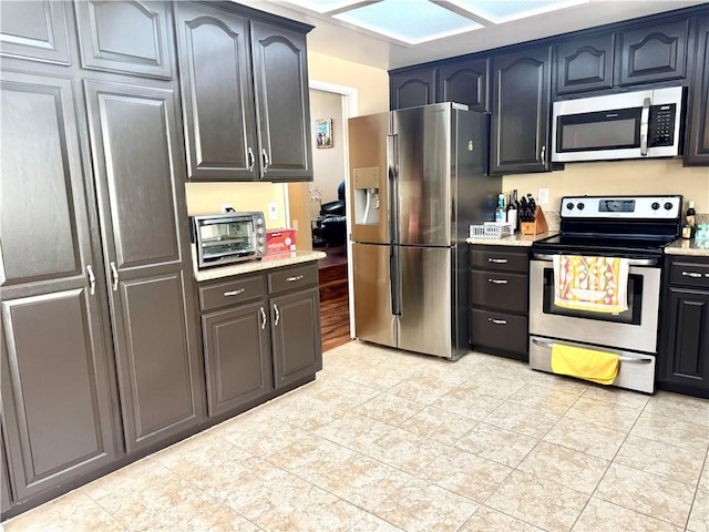 25453 Via Novia, Valencia, CA 91355 - kitchen featuring stainless steel appliances, light tile patterned floors, and light stone counters