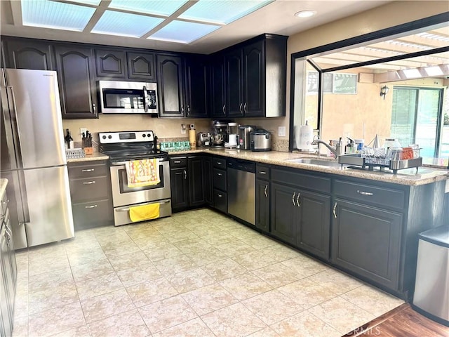 25453 Via Novia, Valencia, CA 91355 - kitchen featuring stainless steel appliances, a sink, healthy amount of natural light, and light stone countertops
