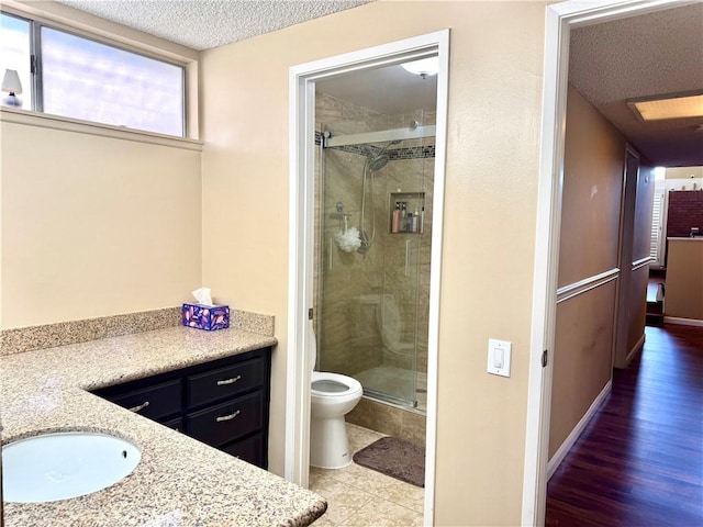 25453 Via Novia, Valencia, CA 91355 - bathroom featuring a shower stall, toilet, vanity, a textured ceiling, and baseboards