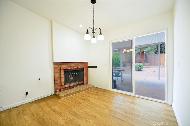 13142 Reedley St, Arleta, CA 91331 - unfurnished living room featuring wood finished floors, a chandelier, a brick fireplace, baseboards, and recessed lighting
