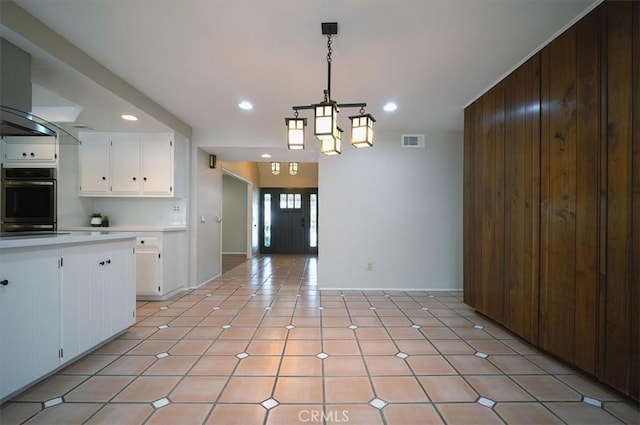 2521 Wildrose Ln, Upland, CA 91784 - kitchen featuring light countertops, white cabinetry, recessed lighting, wooden walls, and decorative light fixtures