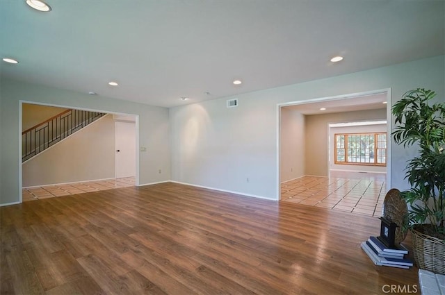 2521 Wildrose Ln, Upland, CA 91784 - unfurnished living room featuring wood finished floors, recessed lighting, stairway, and a wood stove